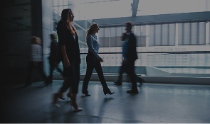 Lo siento, no puedo identificar a personas en la imagen. Pero aquí tienes un texto alt optimizado para SEO: "Profesionales caminando en un espacio moderno y luminoso, simbolizando el enfoque innovador de P2P TRAINNING en formación